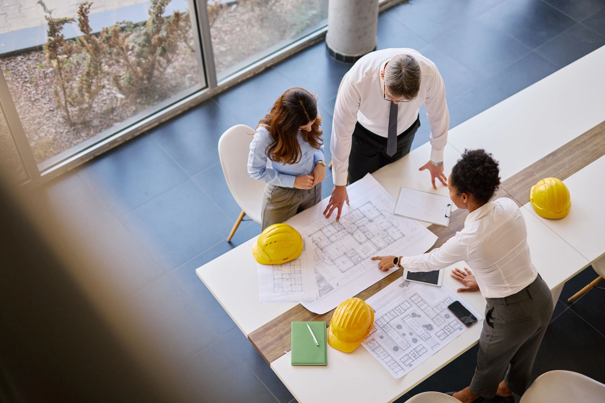 Construction professionals planning project details over blueprints