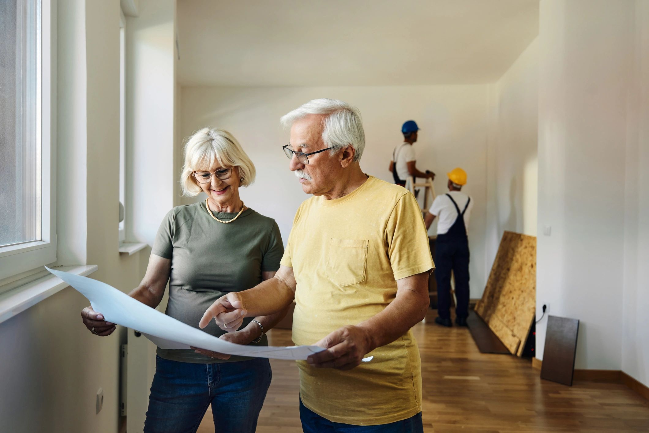 Contractor reviewing renovation plans with homeowners